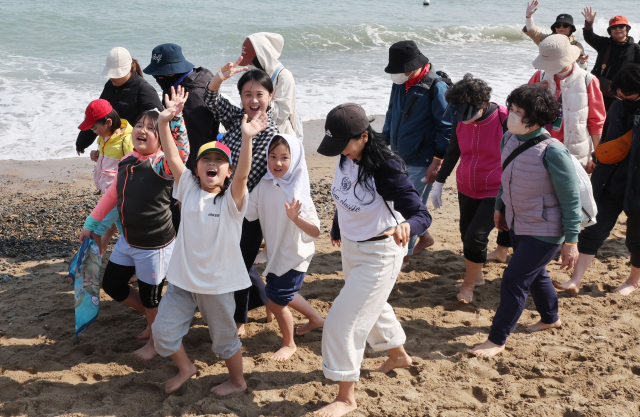 22일 오후 부산 기장군 임랑해수욕장에서 열린 ‘맨발걷기 좋은 도시 부산 세븐비치 어싱 챌린지 <5>임랑’ 행사에서 참가자들이 바닷가를 걸으며 맨발 걷기의 묘미를 즐기고 있다. 정종회 기자 jjh@