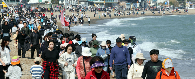 지난 22일 오후 부산 기장군 임랑해수욕장에서 열린 ‘맨발걷기 좋은 도시 부산 세븐비치 어싱 챌린지 임랑편’ 행사에서 참가자들이 바닷가를 걸으며 맨발걷기의 묘미를 즐기고 있다. 정종회 기자 jjh@