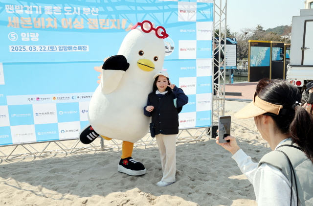 22일 오후 부산 기장군 임랑해수욕장에서 열린 ‘맨발걷기 좋은 도시 부산 세븐비치 어싱 챌린지 임랑’ 행사에서 참가자들이 부산시 홍보캐릭터 부기와 기념사진을 찍고 있다. 정종회 기자 jjh@