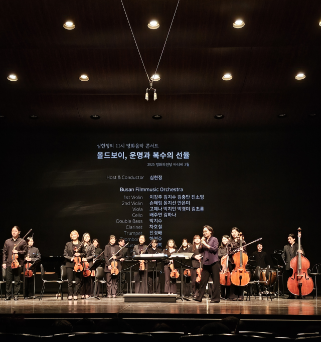 지난 25일 부산 해운대구 영화의전당 하늘연극장에서 진행된 ‘심현정의 11시 영화음악콘서트’에서 호스트 심현정 영화음악감독(가운데 마이크 잡은 사람)이 오케스트라 연주자들과 함께 관객에게 인사하고 있다. 조경건 부산