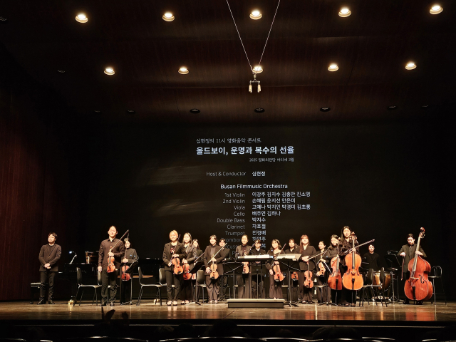 지난 25일 부산 해운대구 영화의전당 하늘연극장에서 진행된 ‘심현정의 11시 영화음악콘서트’가 끝난 뒤 ‘부산 필름 뮤직 오케스트라’ 단원들이 관객에게 인사하고 있다. 조경건 부산닷컴 기자