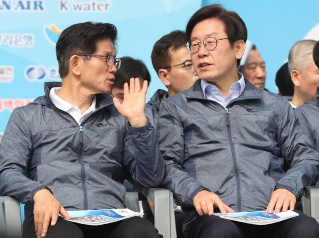 더불어민주당 이재명 대선후보(오른쪽)와 국민의힘 김문수 대선후보가 지난 2018년 5월 1일 서울 송파구 잠실 올림픽 주경기장에서 열린 '한국노총 2018 노동절 마라톤대회'에서 대화하는 모습.연합뉴스