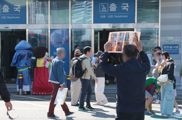 지난 2일 오전 부산항국제여객2터미널 출국장 입구에서 택시 기사들이 손에 팻말을 들고 크루즈 선박에서 하선하는 외국인 관광객을 상대로 호객 행위를 하고 있다.정대현 기자 jhyun@