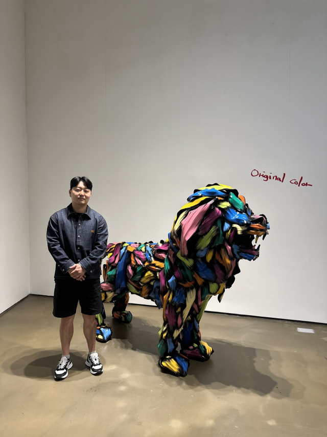 'Lion'(2025) 옆에서 포즈를 취한 김우진 작가. 김은영 기자