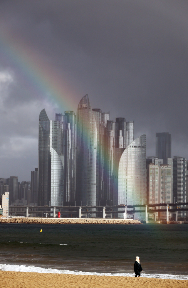 부산기상청은 13일 부산과 울산,경남 지역에 가끔 비 또는 눈이 내릴 것이라고 전망했다.사진은 비가 오락가락한 지난 12일 부산 광안리해수욕장에서 해운대구 마린시티를 바라본 하늘에 뜬 무지개.연합뉴스