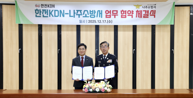 김용호 한전KDN 부사장(왼쪽)과 신향식 나주소방서장이 민관 합동 공공안전 강화를 위한 업무협약서를 들고 기념사진을 찍고 있다.한전KDN 제공