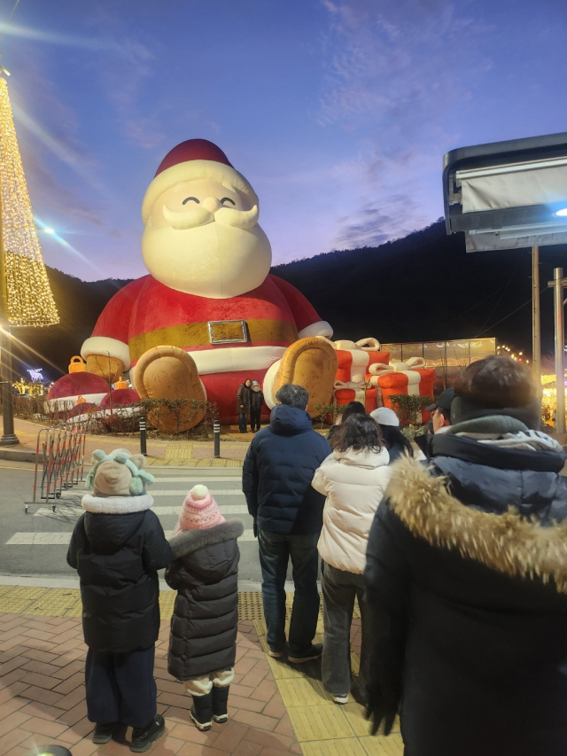 대구시 달성군 송해공원 입구에 세워진 산타할아버지 조형물에 관람객들이 사진을 찍기 위해 줄을 서 있다.