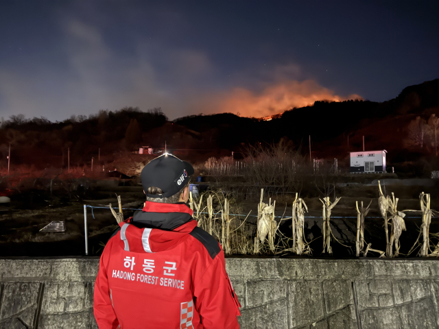 21일 전남 광양시 옥곡면 산불로 국가 소방동원령이 발령된 가운데 경남 하동군 산불진화대 대원이 양 지자체 경계지점에서 산불 확산 여부를 지켜보고 있다.하동군 제공