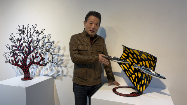 전시장에서 포즈를 취한 진영섭 작가. 오른쪽 작품이 ‘잠시 고인 빛’. 김은영 기자 key66@