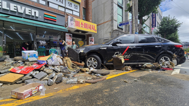 지난 17일 새벽 거제시 일원에 새벽 시간당 100mm가 넘는 극한 호우가 쏟아지면서 지역 곳곳이 초토화 됐다. 거센 물살에 휩쓸려 떠밀려 온 차량이 상가 앞에 잔해물과 뒤엉켜 있다. 부산일보DB