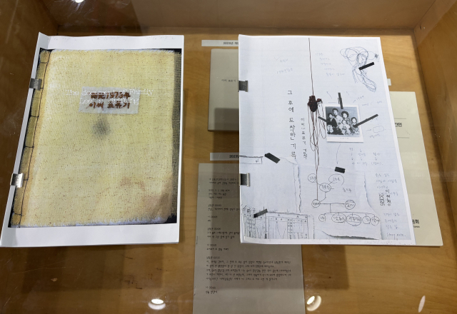 홍티아트센터 전시장 입구 통로에 마련된 이현정 작가의 작업 과정이 담긴 아카이브 테이블. '이씨! 표류기' 곁책 <그 후에 도착한 기록>에는 2023년 이후 알게 된 것과 가족의 목소리 전사문, 녹음되지 
