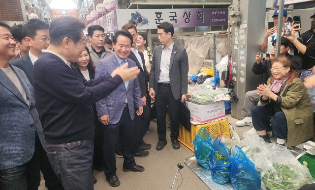 더불어민주당 이재명 대선 후보가 4일 영월 서부시장에서 한 상인과 인사를 하고 있다.