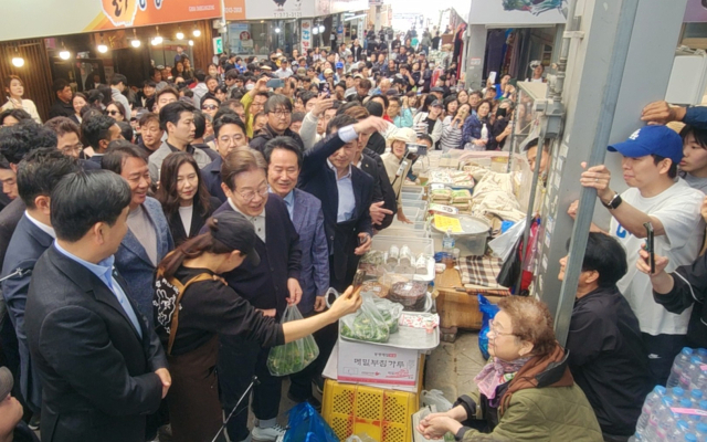 더불어민주당 이재명 대선 후보가 4일 영월 서부시장에서 한 상인과 사진 촬영을 하고 있다.