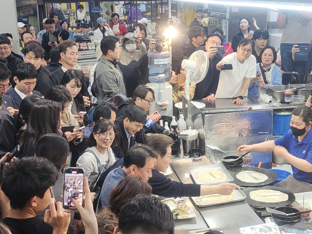 더불어민주당 이재명 대선 후보가 4일 영월 서부시장한 전병집에서 전병을 먹고 있다.