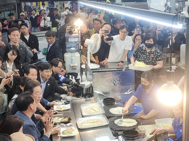 더불어민주당 이재명 대선 후보가 4일 영월 서부시장한 전병집에서 전병을 먹으며 이야기를 나누고 있다.