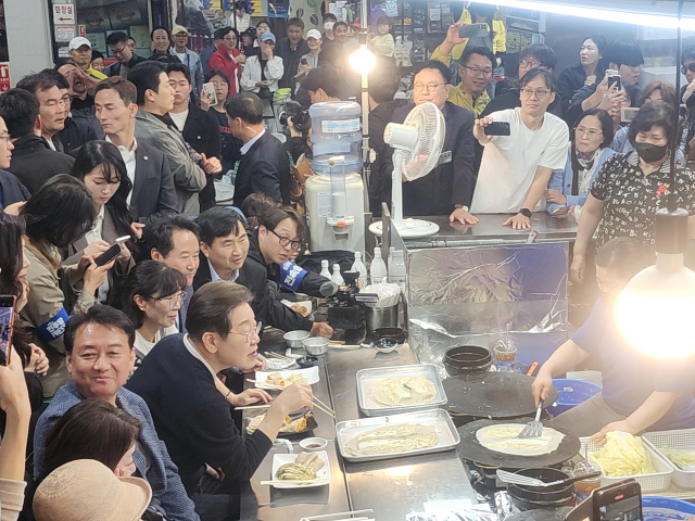 더불어민주당 이재명 대선 후보가 4일 영월 서부시장 한 전병집에서 상인과 이야기를 하고 있다.