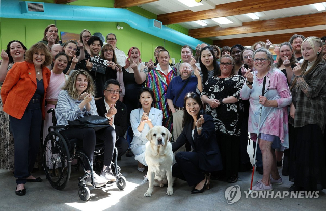 ◇G7 정상회의에 참석하는 이재명 대통령과 함께 캐나다를 방문한 김혜경 여사가 17일(현지시간) 캘거리 국립장애인예술센터에서 은퇴 안내견‘벨라'와 센터활동가들과 기념촬영을 하고 있다. 2025.6.18. 연합뉴스.