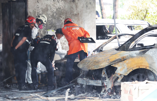 ◇17일 오후 주차장에서 발생한 화재로 다수의 인명피해가 발생한 경기도 광명시 소하동 한 아파트에서 18일 경찰과 소방, 국과수 등 관계자들이 합동 감식을 하고 있다. 2025.7.18 사진=연합뉴스