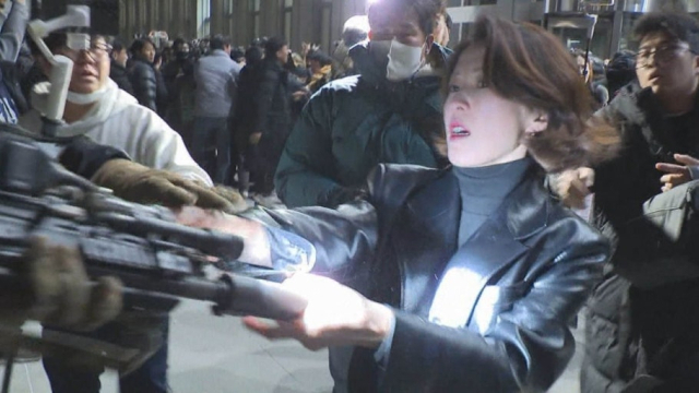 ◇지난 2024년 12·3 비상계엄 선포 당시 국회에 난입한 무장 계엄군의 총구를 잡고 있는 안귀령 대통령실 부대변인의 모습.[연합뉴스TV 제공]