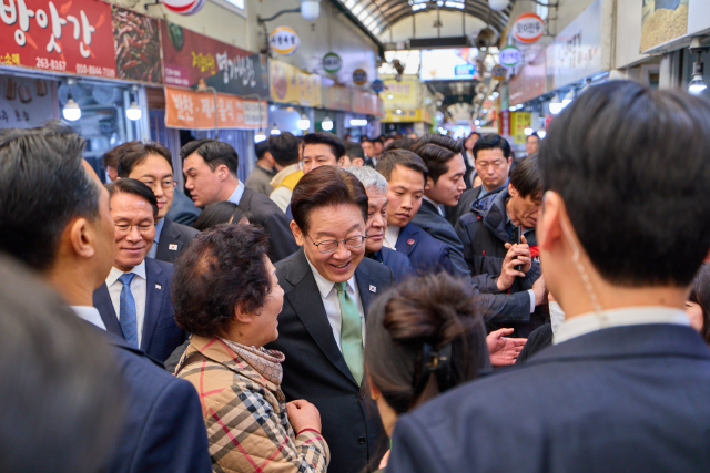 이재명 대통령이 13일 충북 청주시 서원구 사창시장을 찾아 상인 및 시민들과 인사를 하고 있다. 연합뉴스