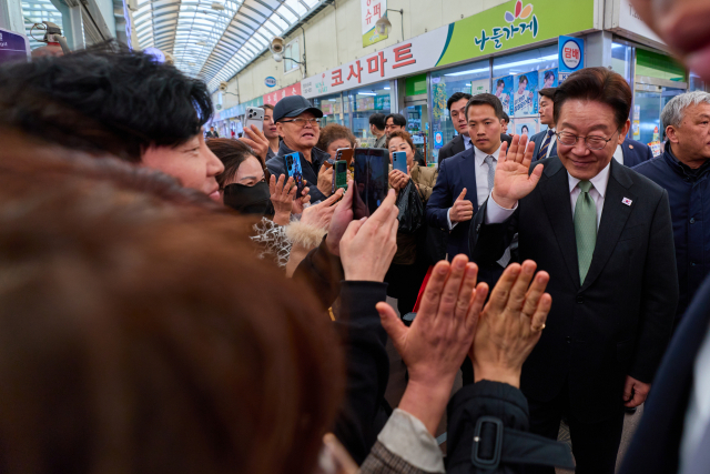 이재명 대통령이 13일 충북 청주시 서원구 사창시장을 찾아 상인 및 시민과 인사를 하고 있다. 연합뉴스