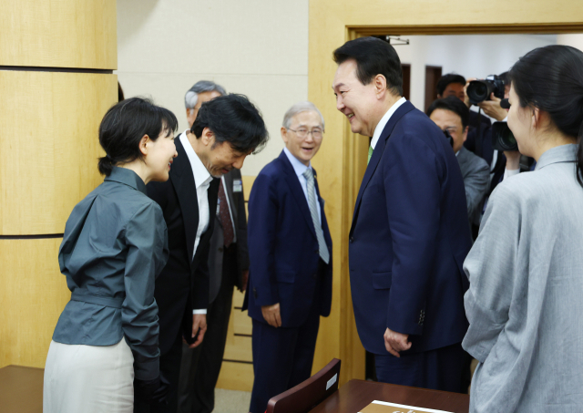 President Yoon Suk-yeol greeting singer Lee Mun-se and his wife, the grandchildren of member Lee Sang-man, who received the National Order of the Mugunghwa Medal in the field of basic nature at the 70th anniversary celebration of the opening of the Korean Academy of Science at the National Academy of Sciences in Seoul Seocho-gu on the 22nd, after the event. Yonhap News