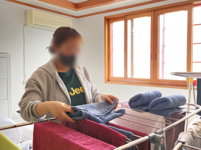 육아와 집안일을 전혀 돕지 않고 생활비도 주지 않는 남편을 대신해 빚을 내가며 세 아이를 홀로 키우고 있는 정지영(43·가명) 씨가 아픈 손목으로 아이의 방에서 빨래를 개고 있다.김지효 기자