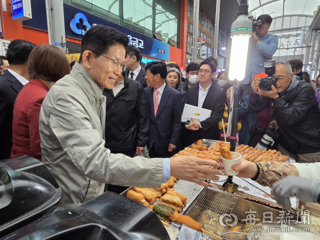 6일 포항 죽도시장을 찾은 김문수 국민의힘 대선후보가 한 상인으로부터 즉석어묵꼬치를 건네받고 있다.신동우 기자