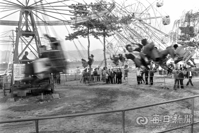1960년대 동촌 유원지에서 양복 차림의 어른들이 회전그네를 타고 있다.이 회전그네는 1963년 5월 29일 유기장 허가를 받고 운영에 들어갔다.사진=매일아카이빙센터
