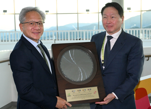 ゼンスン硫黄エンビデ−ア CEOが 31日慶北慶州芸術の殿堂で開かれたアジア太平洋経済協力体(APEC) 最高経営者(CEO) サミットに参加してチェ・テオン大韓商工会議所会長から SKハイニクスの HBM4 半導体Waferを贈り物でもらっている