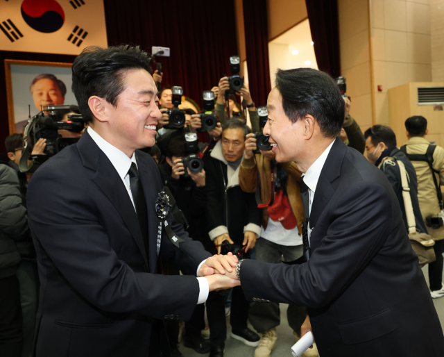 강훈식 대통령 비서실장과 김영삼 전 대통령 아들 김현철 씨가 21일 서울 동작구 국립서울현충원에서 열린 고 김영삼 전 대통령 서거 10주기 추모식에서 인사를 나누고 있다. 연합뉴스