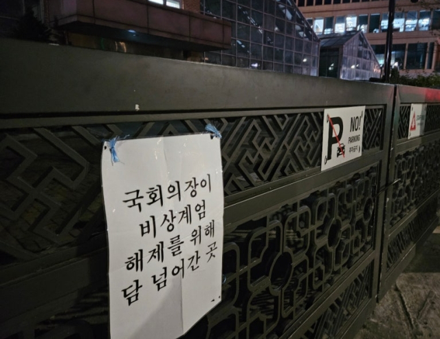 서울 여의도 국회 담장에 지난해 12월 3일 비상계엄 당시 우원식 국회의장이 월담했던 부분을 표시한 문구가 붙어 있다. 연합뉴스