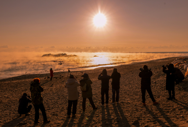 2026년 병오년(丙午年) 새해를 닷새 앞둔 28일 경주 문무대왕릉을 찾은 시민들이 수평선 위로 떠오르는 일출을 바라보고 있다.김영진 기자 