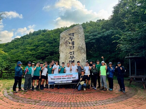 8월 18일 아침, 강원도 진부령에서 30일간의 종주를 시작하며 한 자리에 섰다. 황철현 신부(가운데 앉은 사람)와 현수막을 든 김미곤 대장(가운데)과 청소년들과 지원 산악인들.