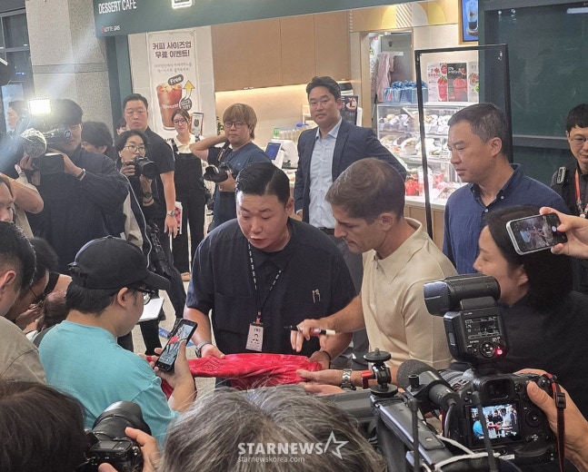 13일 인천국제공항을 통해 입국한 뒤 인터뷰를 마치고 현장을 찾은 팬들에게 사인을 해주고 있는 로베르트 모레노 감독. /사진=김명석 기자