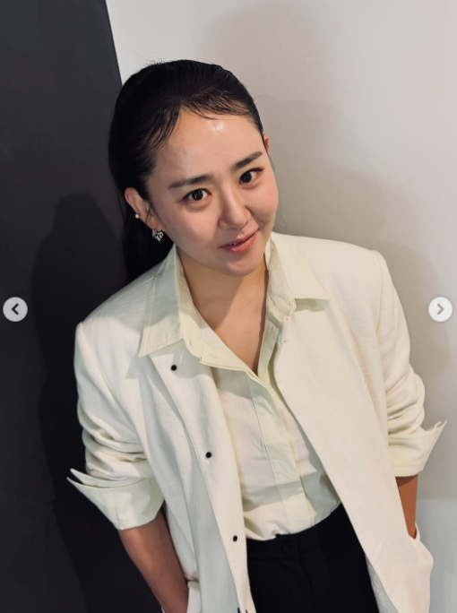 白いジャケット姿でカメラを見つめるムン・グニョン