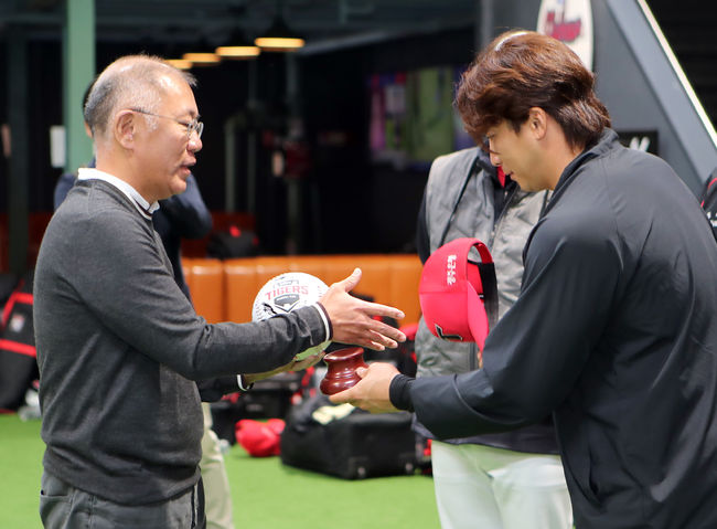정의선 회장(왼쪽)이 주장 나성범 선수로부터 사인볼을 받고 악수를 나누고 있다.