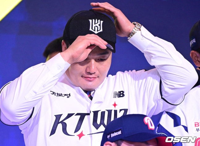[OSEN=최규한 기자] 21일 오후 서울 잠실동 롯데호텔 월드 크리스탈볼룸에서 ‘2027 KBO 신인드래프트’가 열렸다. 이번 신인드래프트는 2025시즌 순위의 역순에 따라 키움 히어로즈, 두산 베어스, KIA 타이거즈, 롯데 자이언츠, KT 위즈, NC 다이노스, 삼성 라이온즈, SSG 랜더스, 한화 이글스, LG 트윈스 순서로 1라운드부터 11라운드까지 지명할 수 있다. 최지만이 전제 15순위로 KT 위즈에 지명된 뒤 기념촬영을 준비하고 있다. 2026.09.21 / dreamer@osen.co.kr