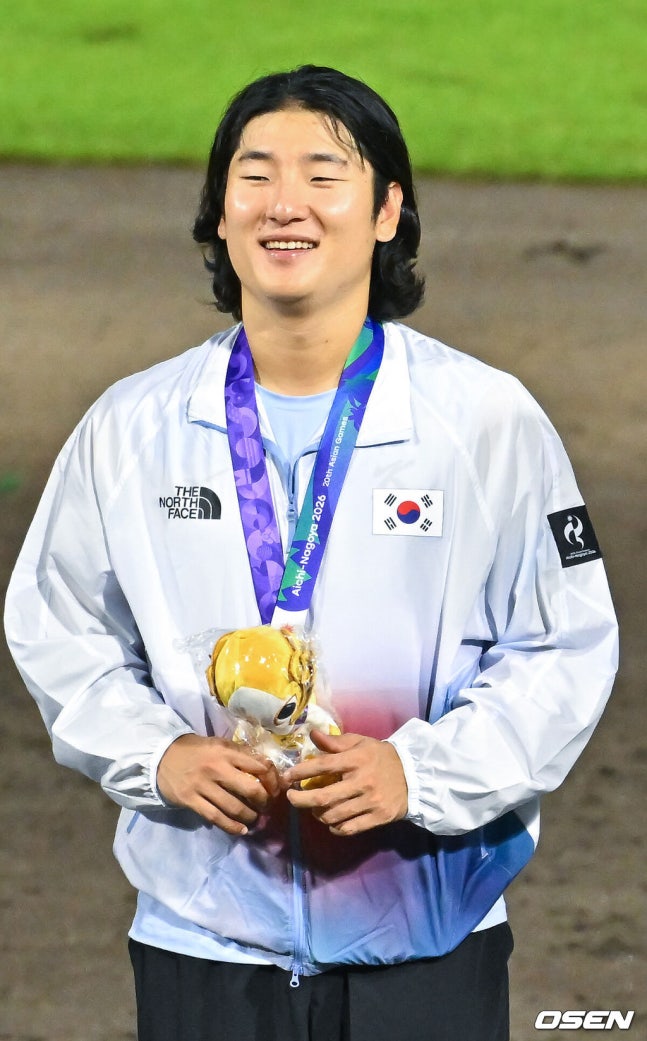 [OSEN=도요하시(일본), 박준형 기자] 한국야구가 우여곡절 끝 아시안게임 5회 연속 금메달을 해냈다. 류지현 감독이 이끄는 한국 야구대표팀은 27일 일본 아이치현 도요하시 시민구장에서 열린 2026 아이치-나고야 아시안게임 일본과 결승전에서 3-1로 승리했다.시상식에서 곽빈이 미소 짓고 있다. 2026.09.27 / soul1014@osen.co.kr