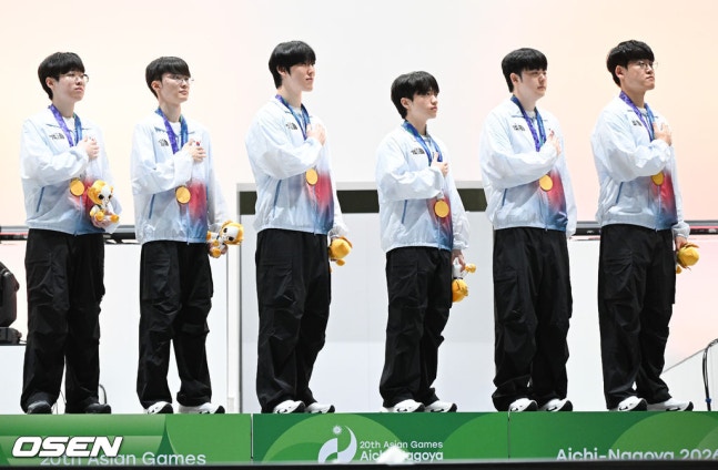 [OSEN=도코나메(일본), 박준형 기자] 1, 2세트의 아슬아슬했던 위기를 연속 대역전극으로 이겨낸 대한민국 e스포츠 대표팀이 대만을 완전히 압도하며 금메달을 차지햇다. 강동훈 감독이 이끄는 대한민국 대표팀은 2일 일본 아이치현 도코나메시 아이치 스카이 엑스포에서 열린 2026 아이치·나고야 아시안게임 e스포츠 LoL 결승전 대만과의 3세트 경기에서 시작부터 상체와 정글 주도권을 단단히 움켜쥐며 대만을 압박한 끝에 29분 만에 넥서스를 깨뜨리고 금메달을 확정 지었다.시상식에서 LoL 한국대표팀이 국민의례를 하고 있다. 2026.1