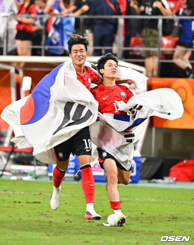 [OSEN=도요타(일본), 박준형 기자] 미쳤다! 엄지성(24, 스완지 시티)이 결승골로 한국축구를 살렸다. 이민성 감독이 이끄는 U23 남자축구대표팀은 3일 오후 7시 30분 도요타 스타디움에서 개최된 아이치-나고야 아시안게임 2026 결승전에서 엄지성의 결승골이 터져 숙적 일본을 1-0으로 제압했다. 경기종료 후 김명준과 양민혁이 태극기를 들고 그라운드를 돌고 있다. 2026.10.03 / soul1014@osen.co.kr