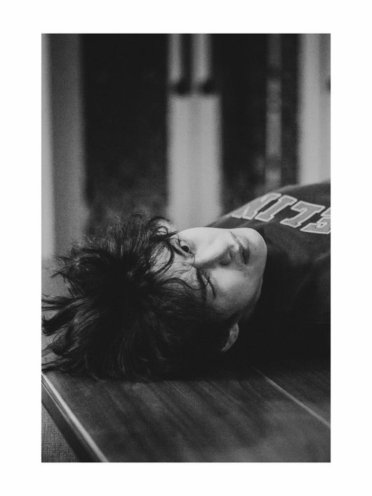 ジョングクが撮影した、ソファに横たわるVのモノクロ写真