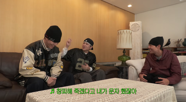 YouTube動画の一場面。室内のソファに座る3人の男性のうち、中央の男性が身ぶりを交えて話している