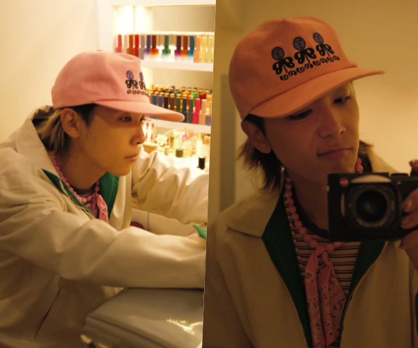 ピンクの帽子とスカーフ姿でカメラを手にするイ・ホンギの写真
