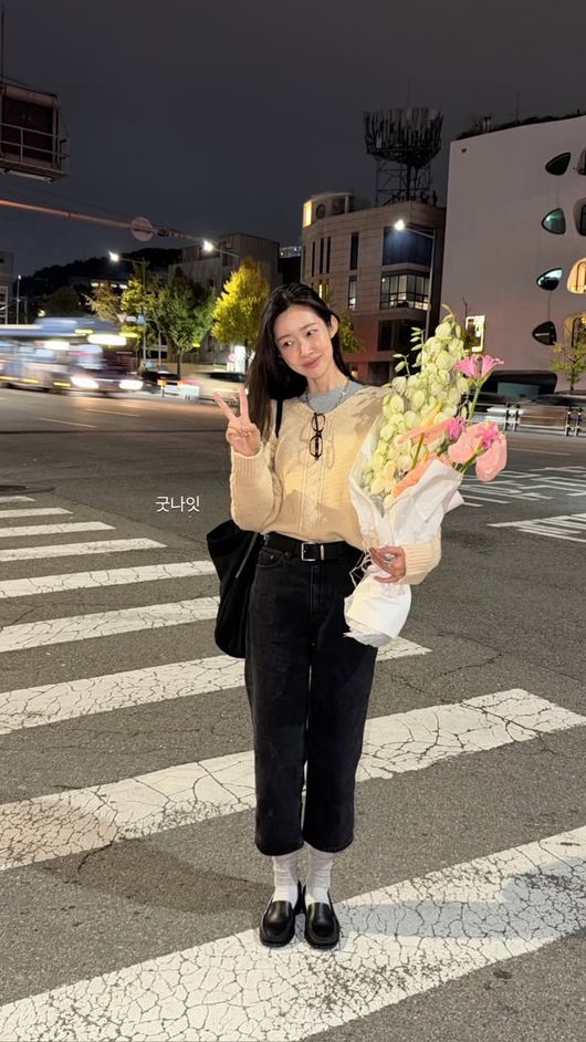 夜の横断歩道で花束を持ち、ピースサインをするチャ・ジョンウォン