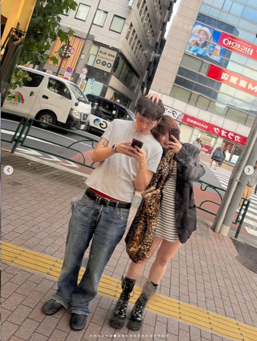 日本の街角で並んで写真に写るヒョナとヨン・ジュンヒョン