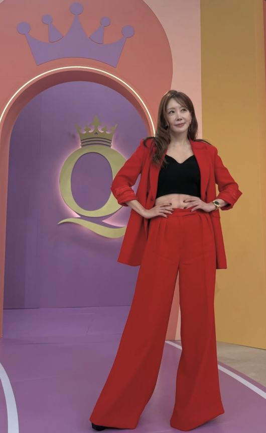 赤いジャケットとワイドパンツに黒のクロップド丈インナーを合わせ、スタジオでポーズを取るキム・ジョンウン