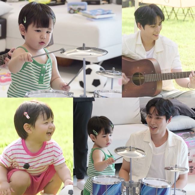 子ども用ドラムを演奏するハルと、アコースティックギターを手にするYoung Kを写した写真