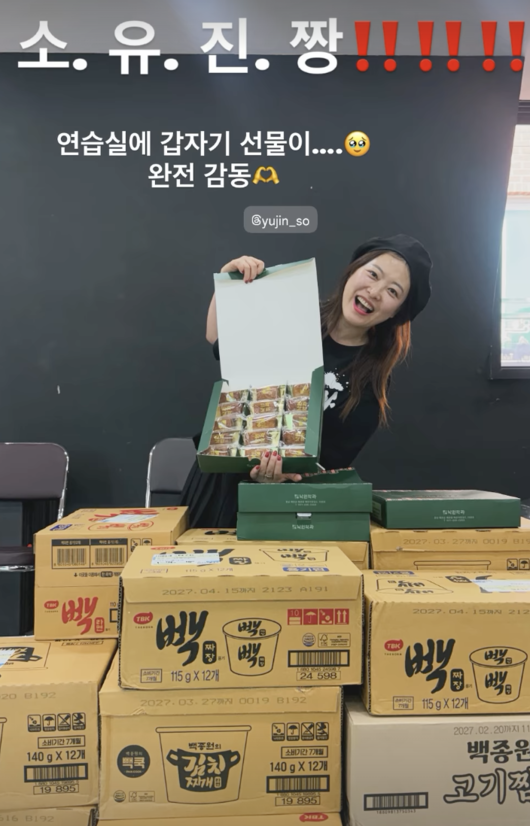 練習室でソ・ユジンから届いたお菓子の箱を持ち、笑顔を見せるシム・ジンファ
