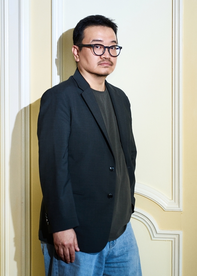 黒いジャケット姿で立つヨン・サンホ監督